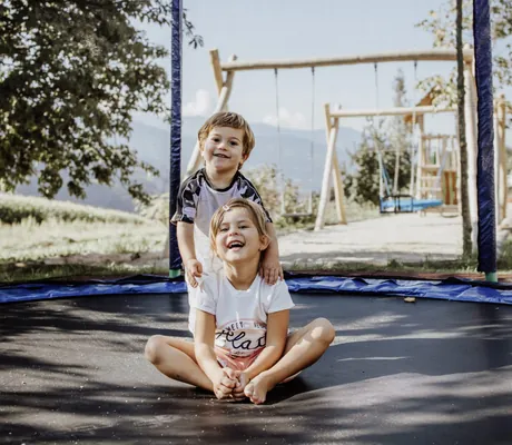 zwei Kinder lachen auf dem Trampolin des Das Mühlwald