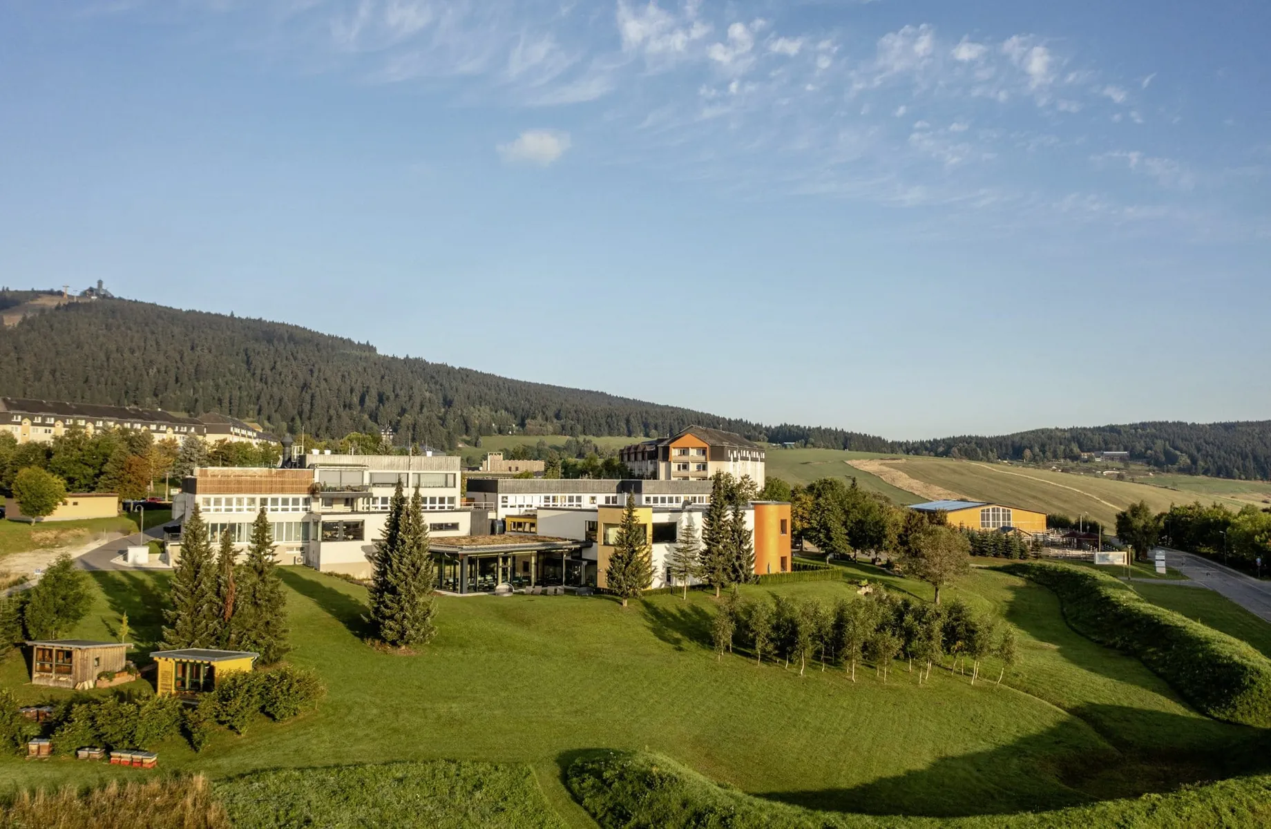 Außenansicht Elldus Resort mit Blick auf Gartenanlage mit zwei kleinen Hütten