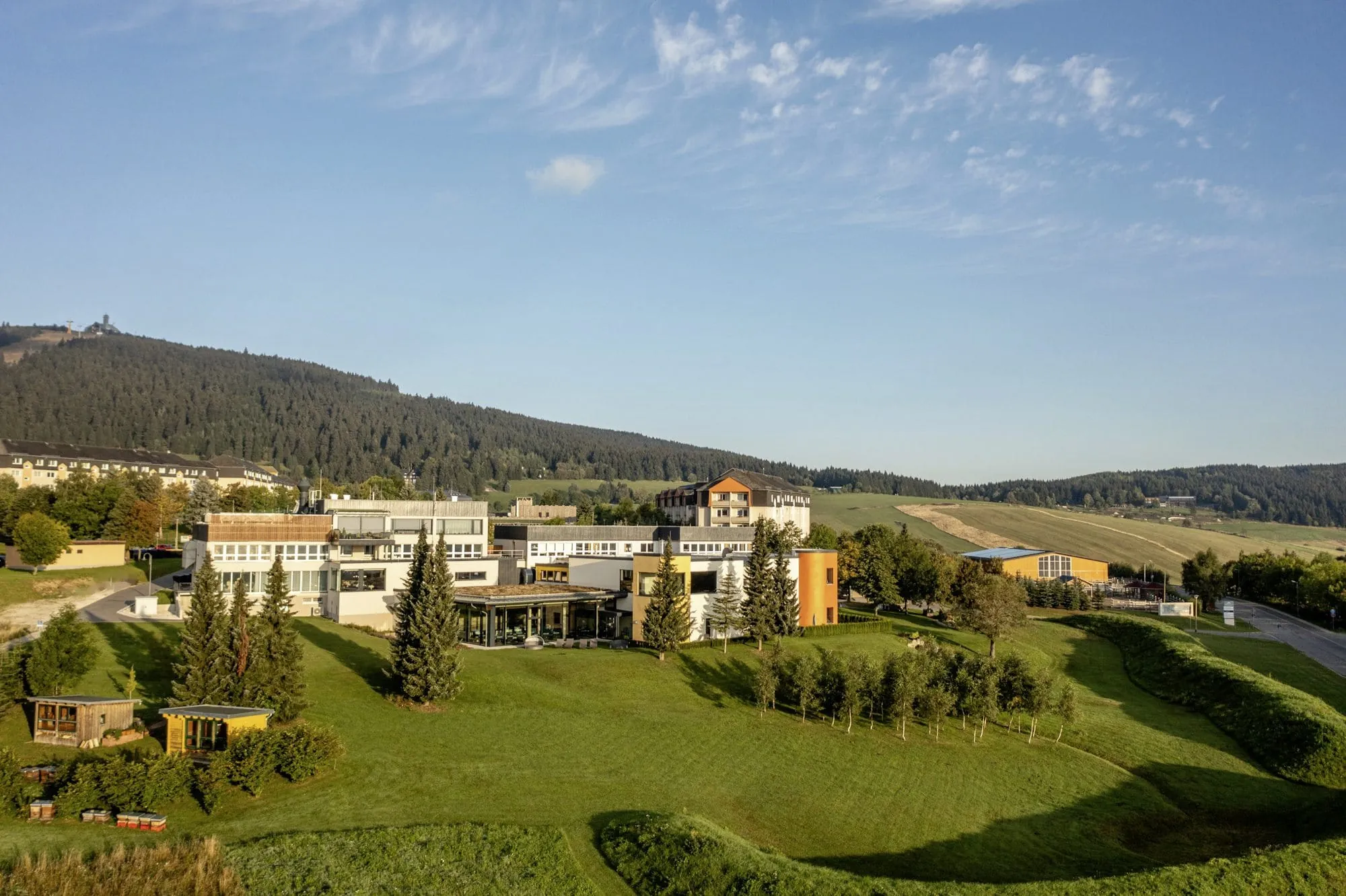 Außenansicht Elldus Resort mit Blick auf Gartenanlage mit zwei kleinen Hütten
