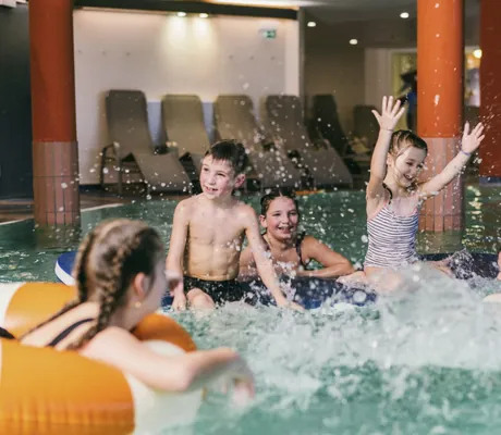 eine Gruppe von Kindern planscht im Indoorpool des Reiters Finest Family Resort