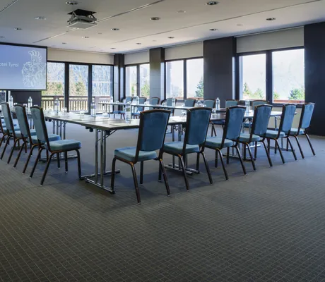 In U-Form mit blauen Stühlen bestuhlter Konferenzraum