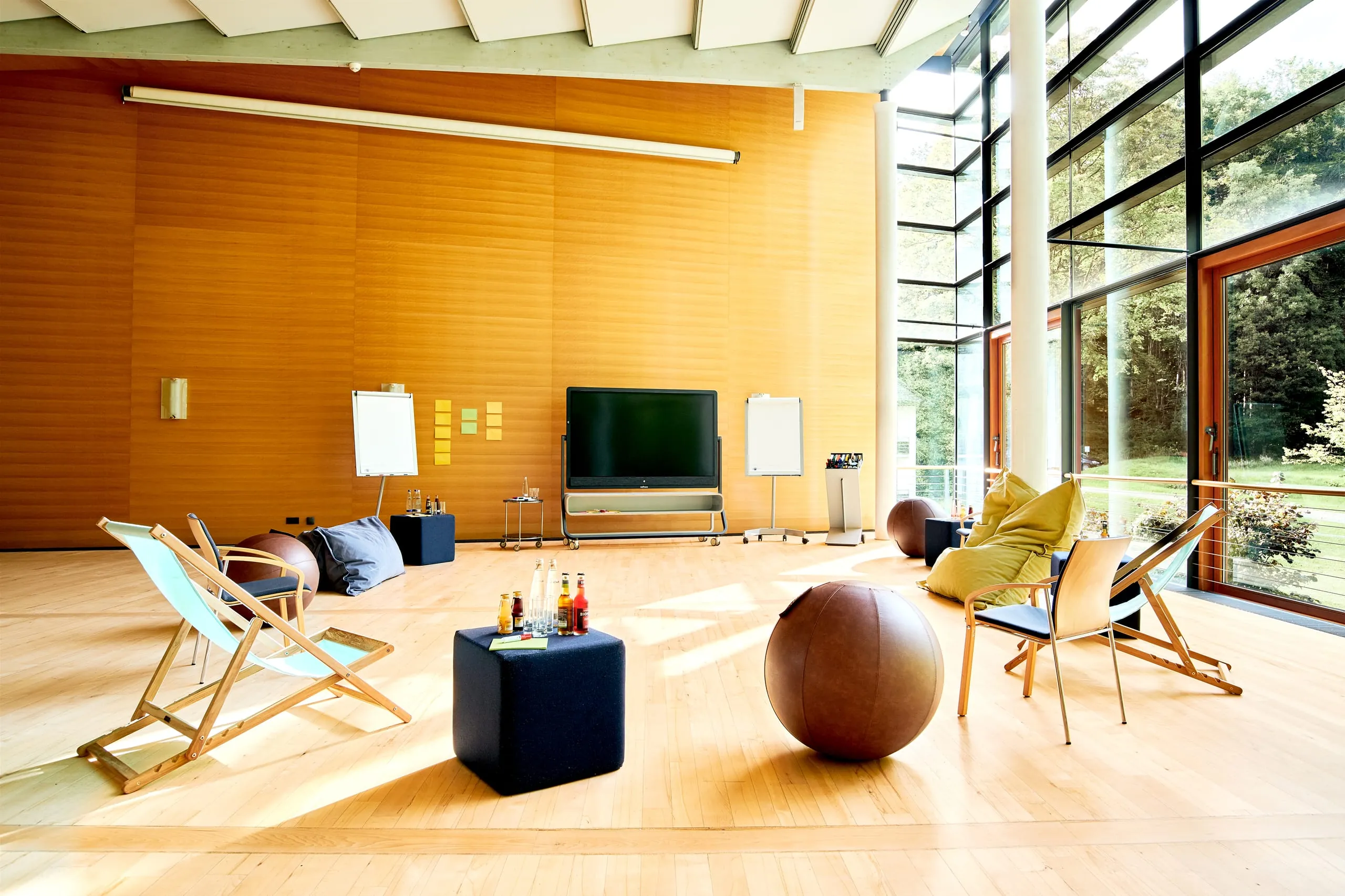 Kreativer Tagungsraum mit freier Stuhlanordnung und Sitzb&auml;llen vor wandhohem Fenster in Westerham Die Akademie