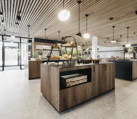 Speisetheken in Holzoptik unter beleuchteter Holzdecke im Landhotel Voshövel