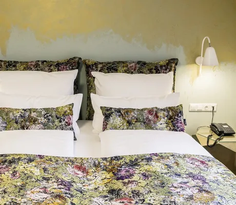 Zimmer mit Doppelbett und geblühmten Bezug im Landhotel Voshövel