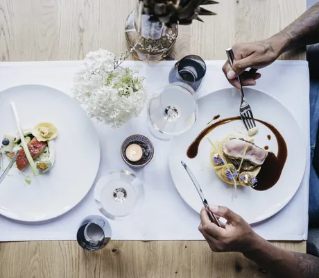 Blick von oben auf zwei Gerichte auf weißen Tellern im Restaurant