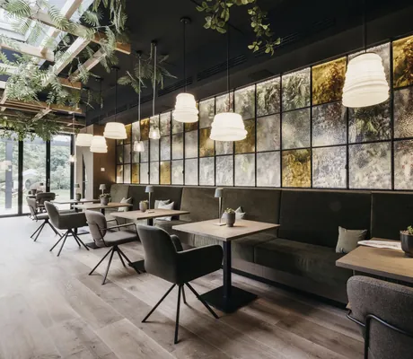 Tische im Restaurant des Landhotel Voshövel vor LED-Lichterwand mit verschiedenen Mustern