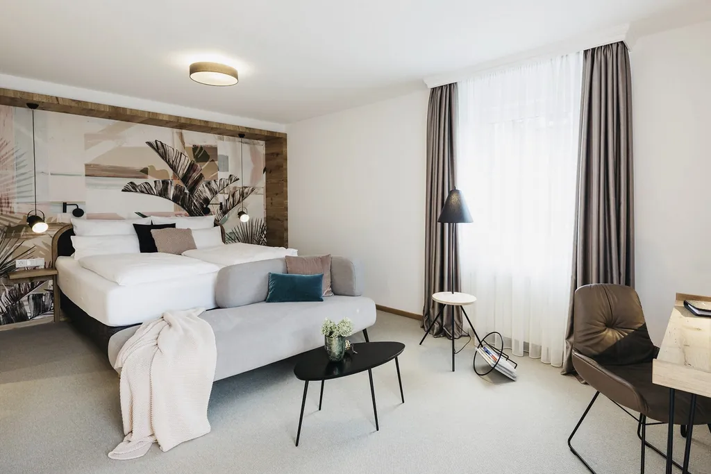 elegantes Doppelzimmer mit Palmentapete und grauen Vorhängen