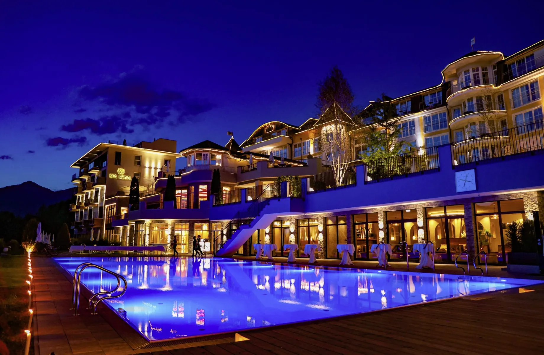 Außenansicht des Panorama Royal mit Outdoorpool im blauen Licht der Nacht