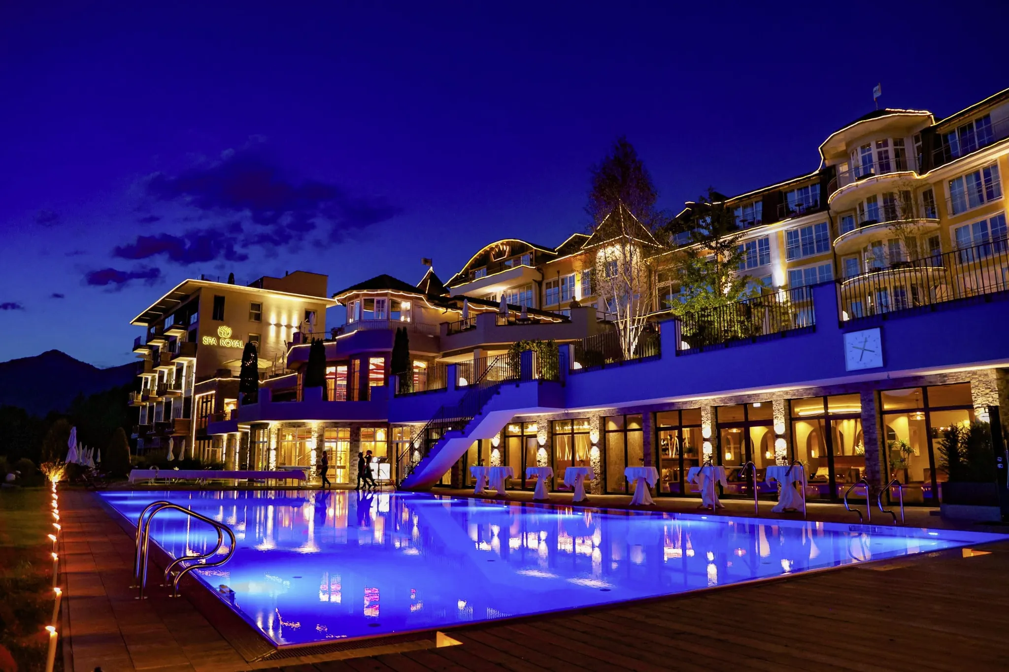 Außenansicht des Panorama Royal mit Outdoorpool im blauen Licht der Nacht