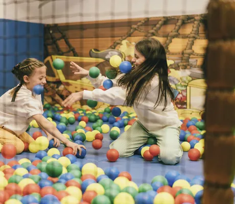 zwei Mädchen bewerfen sich im Bällebad des Reiters Allegria mit bunten Bällen