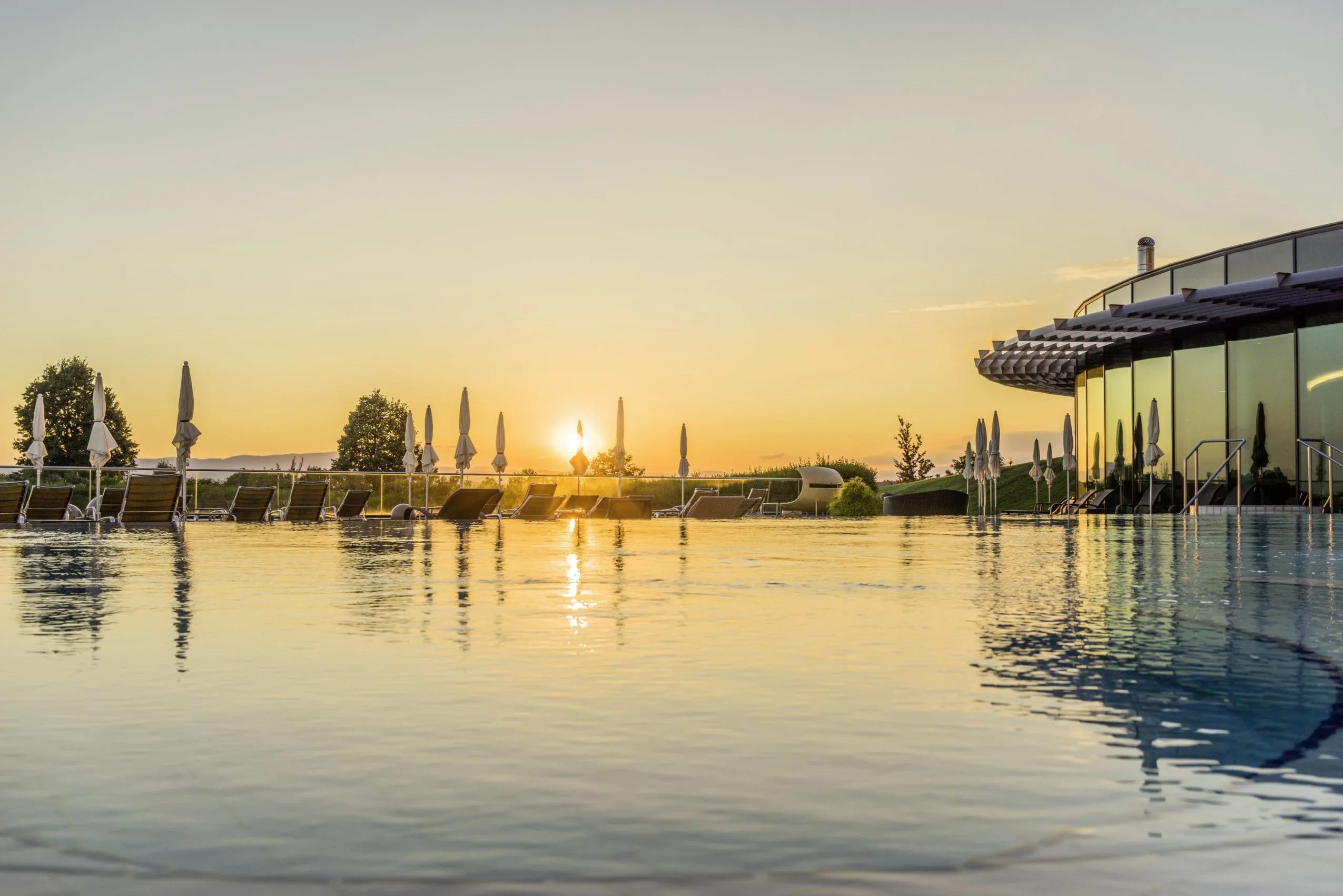 Au&szlig;enpool des Reiters Supreme 5* Hotel im Sonnenuntergang mit Rondell des Spabereichs