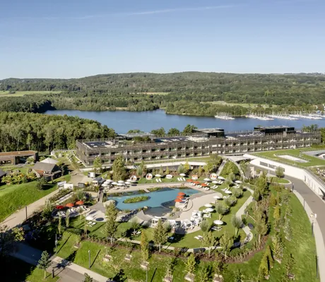 Gesamtansicht der Seezeitlodge mit Blick auf den Naturbadeteich und den angrenzenden See