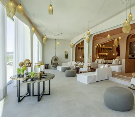 Ruheraum in der Seezeitlodge mit grauen Poofs und terrakottafarbenen Liegekojen