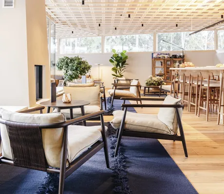 Barbereich mit Decke aus Holzstäben und Sitzmöbeln auf dunkelblauem Wollteppich im Sensoria Dolomites