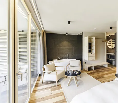 Suite mit freistehender Badewanne und beigen Naturmaterialien