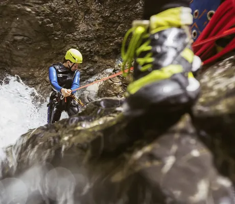 Frau seilt sich beim Canyoning ab