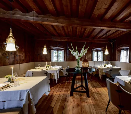 mit dunklem Holz verkleidetes Restaurant im Böglerhof mit Mitteltisch mit Blumenvase