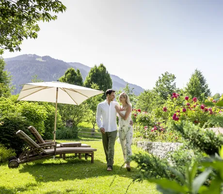 Pärchen läuft umarmt durch den Wellnessgarten des Böglerhof