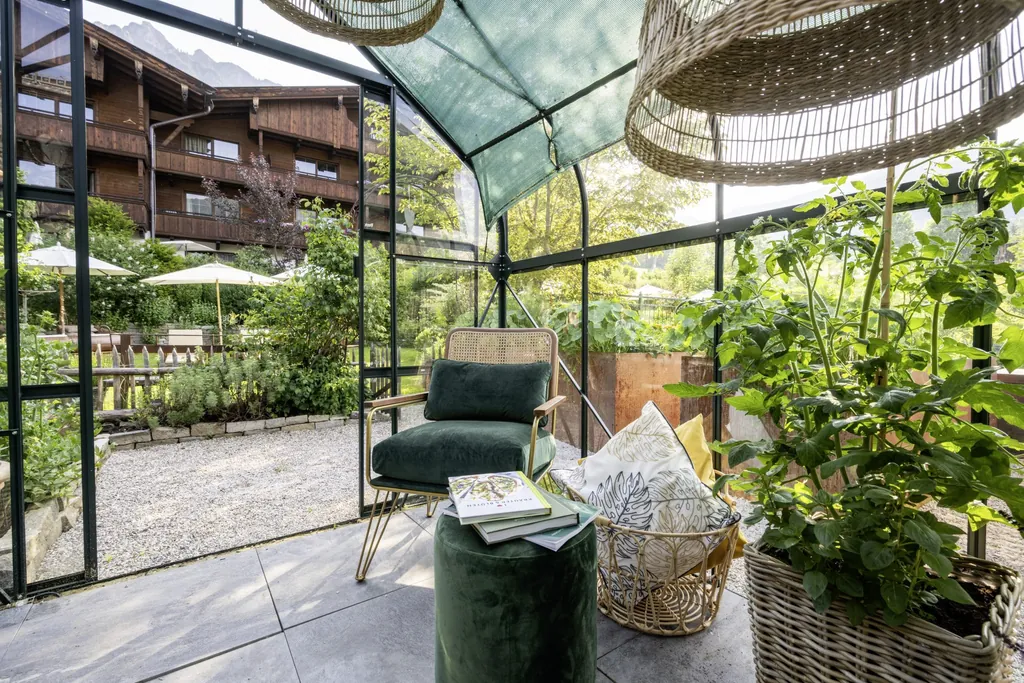 Wintergarten im B&ouml;glerhof mit Rattanstuhl und Korblampen