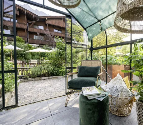 Wintergarten im Böglerhof mit Rattanstuhl und Korblampen