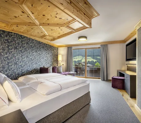 Doppelzimmer im Der Böglerhof mit dunkelgrauer Blumentapete und Blick nach außen