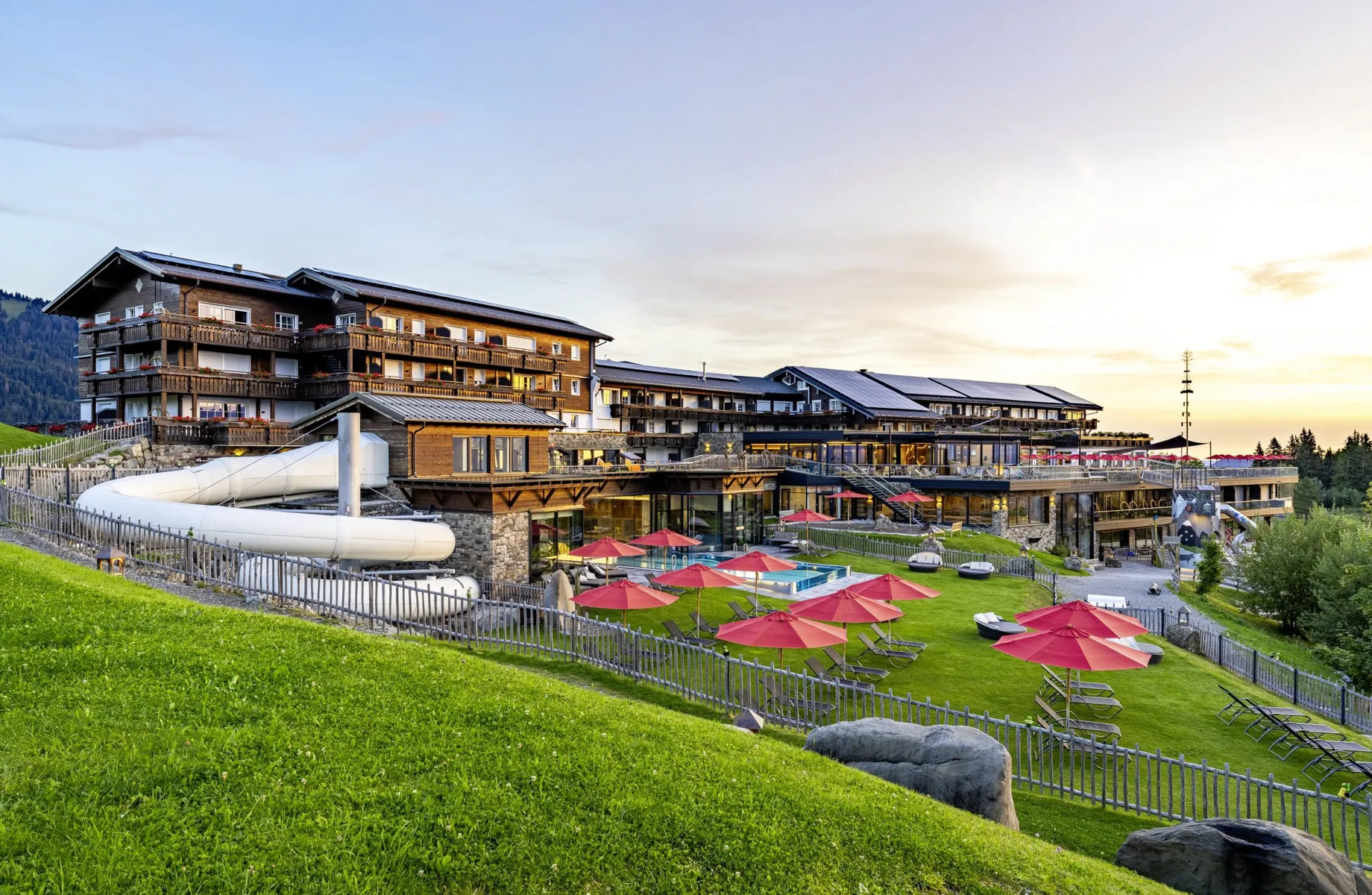 Außenansicht des Allgäuer Berghof mit Rutschen und Pool im Sommer
