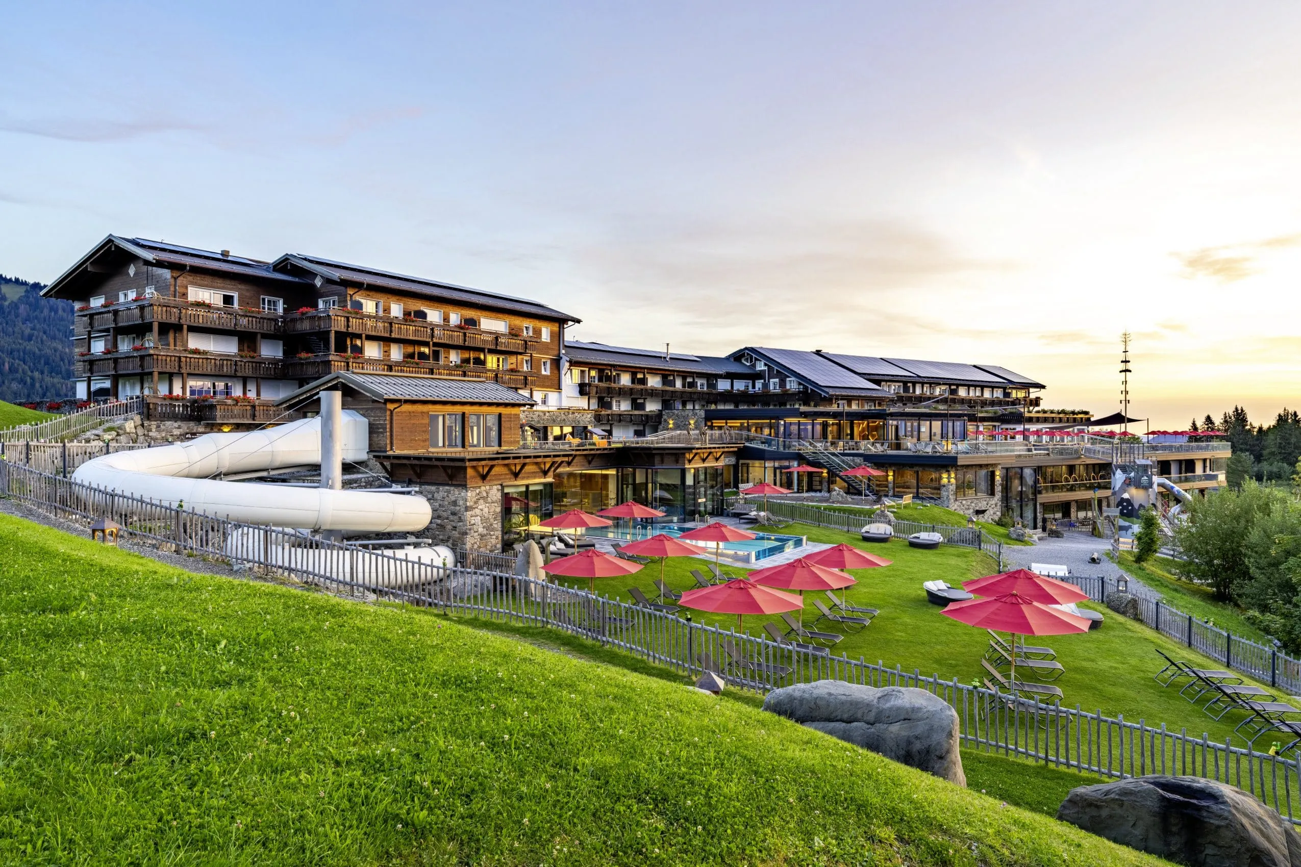 Außenansicht des Allgäuer Berghof mit Rutschen und Pool im Sommer