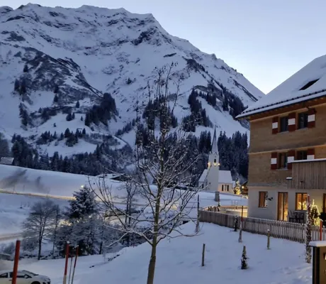 Aussenansicht des Berghaus Schröcken an einem Winterabend