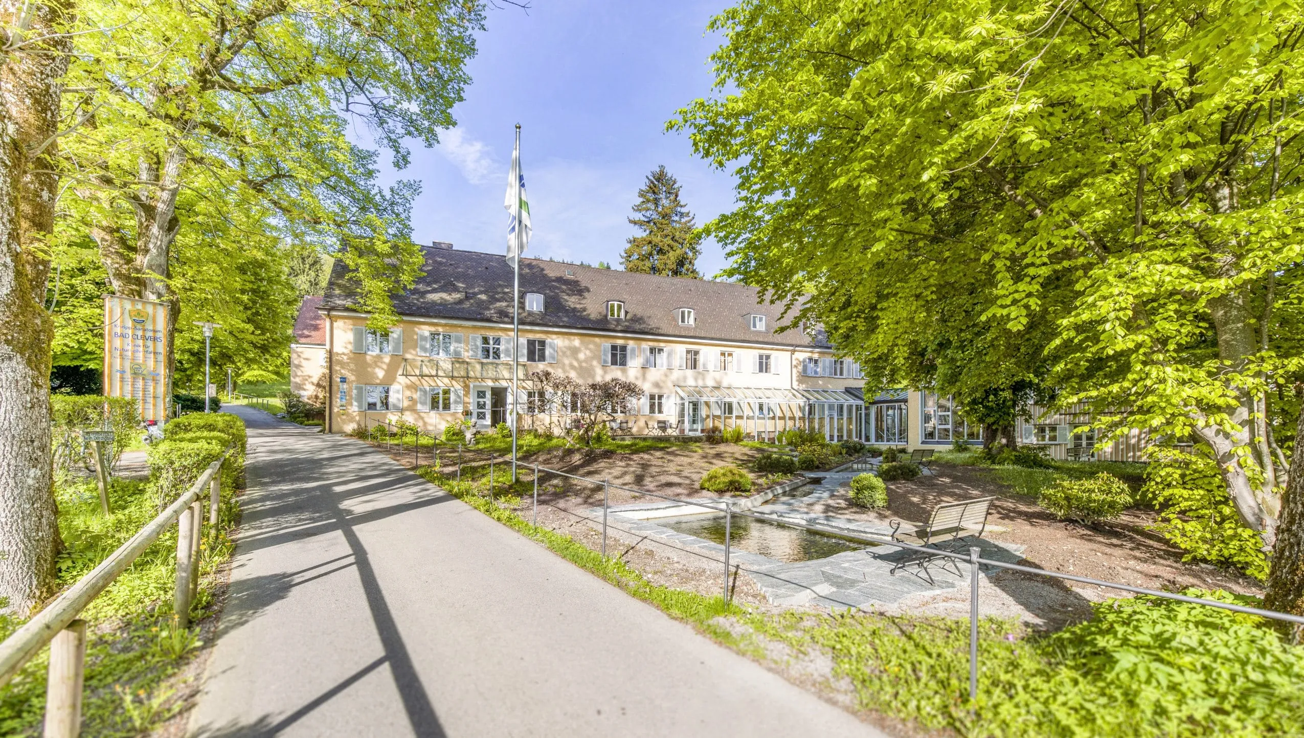 Außenaufnahme des Bad Clevers Gesundheitsresort mit Blick auf den Kneippweg vor dem Hotel