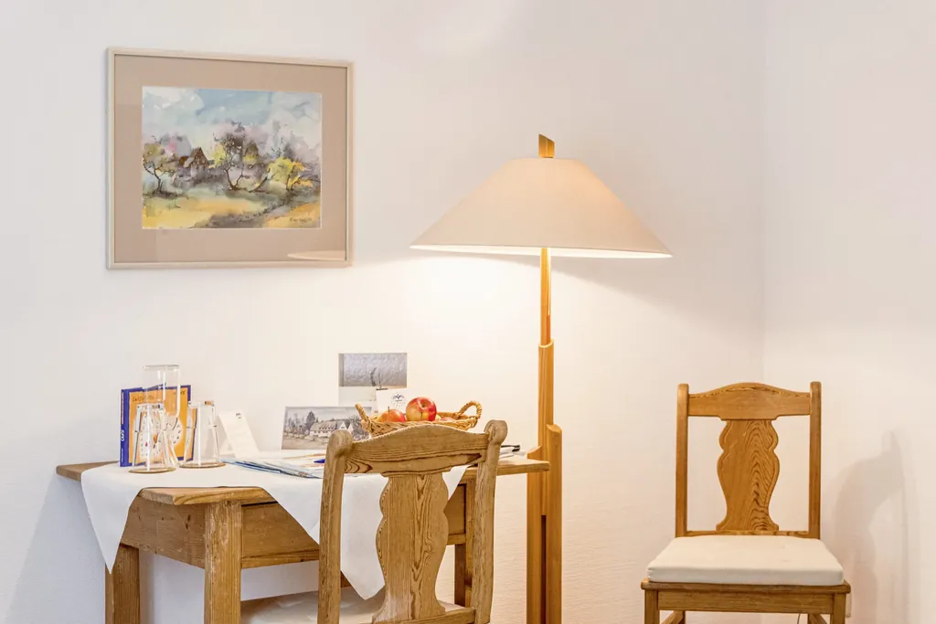 traditioneller Holztisch mit zwei Bauernstühlen und Stehlampe im Bad Clevers Gesundheitsresort