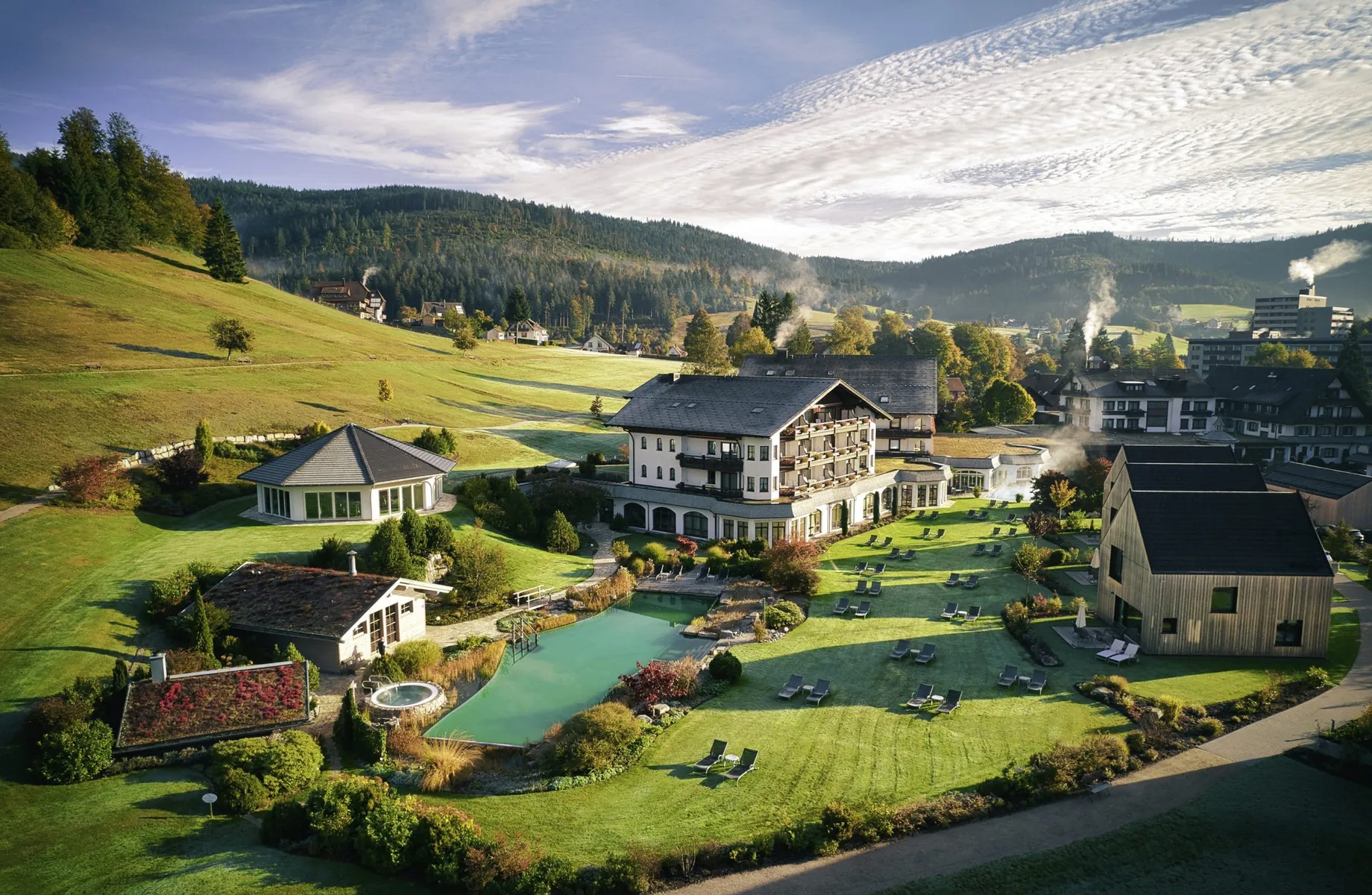 Gesamtansicht Hotel Engel Obertal mit Haupthaus, Chalets und Naturbadesee