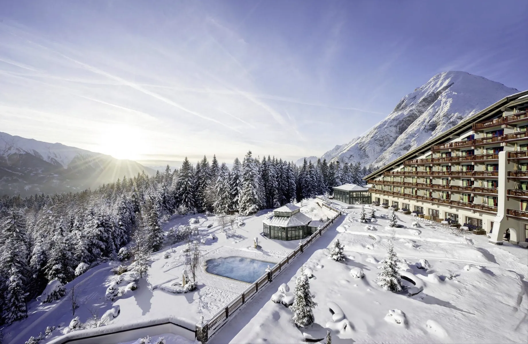 Fassade und Outdoorpool des Interalpen-Hotel Tyrol im Winter