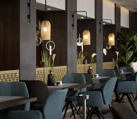 blaue Sessel und Hängeleuchtenim Restaurant des La Maiena Meran Resort
