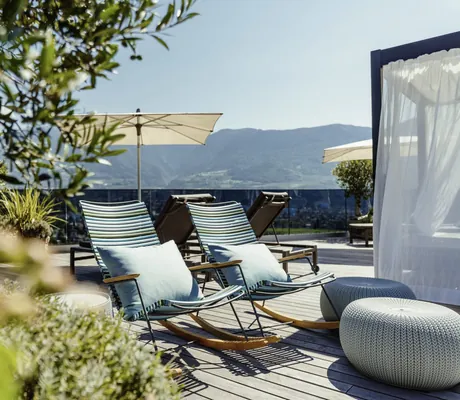 zwei gestreifte Schaukelstühle mit Kissen auf der Dachterrasse des La Maiena Meran Resort