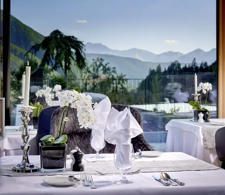 weiß eingedeckter Tisch mit Orchidee im Restaurant des Hotel Quelle