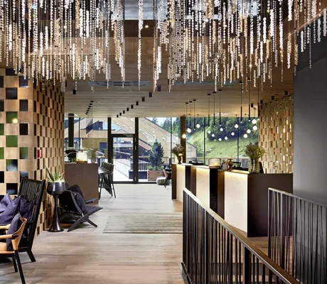 Lobby mit großen schwarzen Holzsesseln und von der Decke hängenden Ketten im ZillergrundRock
