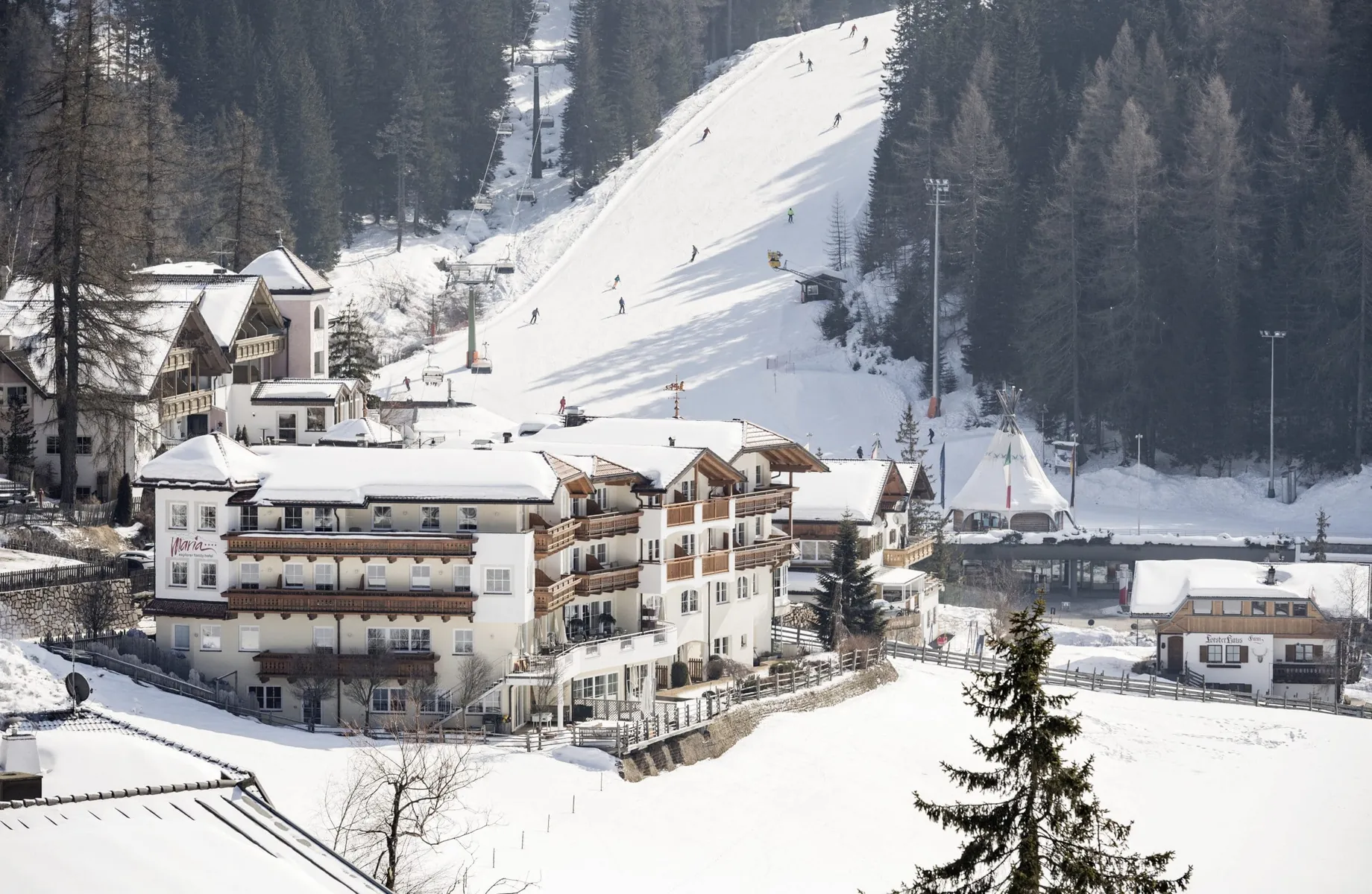 Family Adventure Hotel Maria in Schneelandschaft vor Piste mit Skilift