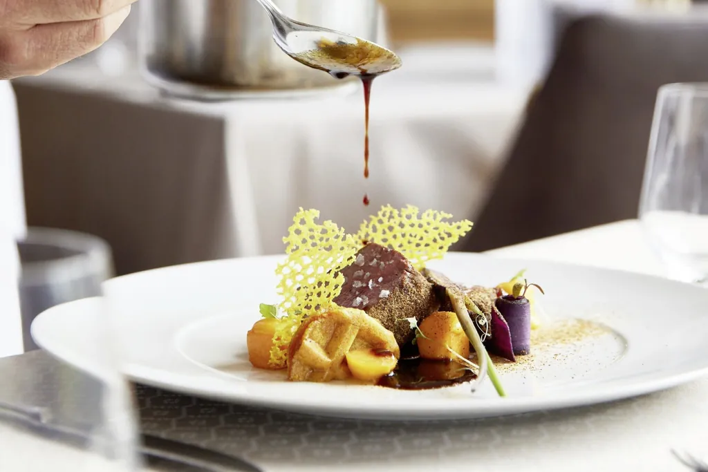 Kulinarisch anspruchsvolles Gericht wird mit Sauce finalisiert