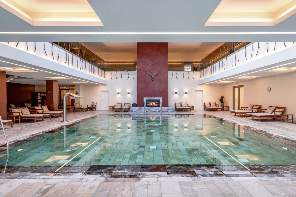 Luxuriös gestalteter Wellnessbereich des Wald & Schlosshotel Friedrichsruhe mit großen Indoorpool und Marmorfliesen