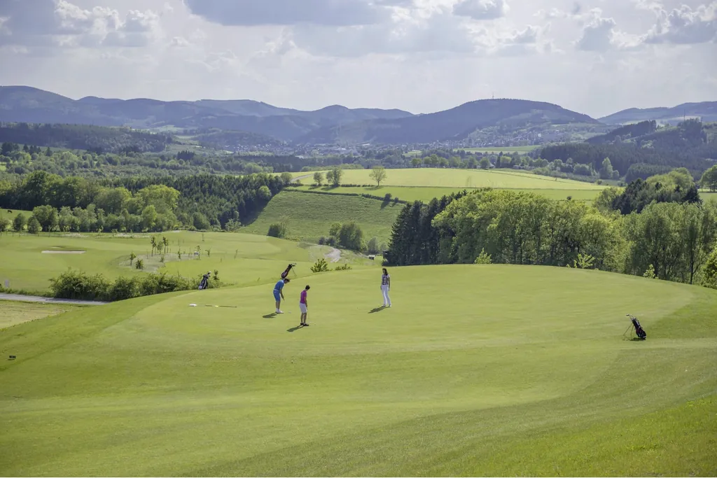 Blick auf den Golfplatz des Golfclubs Schmallenberg mit einigen Golfspielern