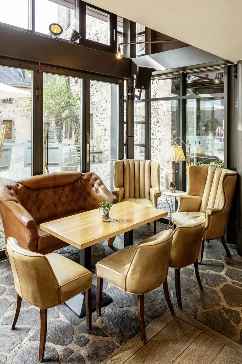 Havanabar im h&ocirc;tel schloss romrod mit Ledersesseln und bodentiefen Fenstern