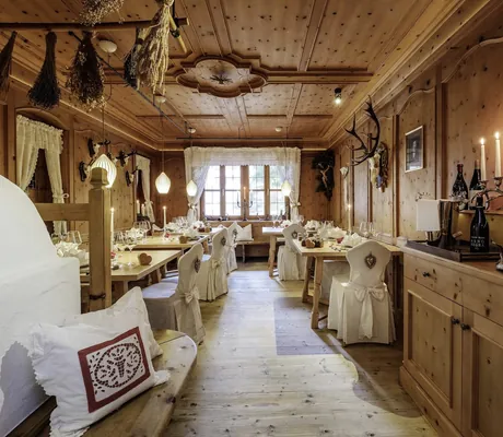 rustikale Gourmetstube mit weißen Stuhlhussen und Ofen im Das Rübezahl