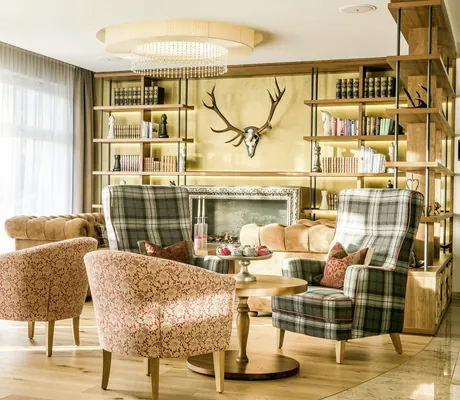 Lobby mit karierten Ohrensesseln und Geweih über dem Kamin im Das Rübezahl