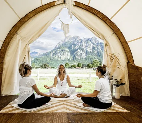 blonde Therapeutin zelebriert mit zwei Frauen eine Meditation im Pavillon des Das Rübezahl