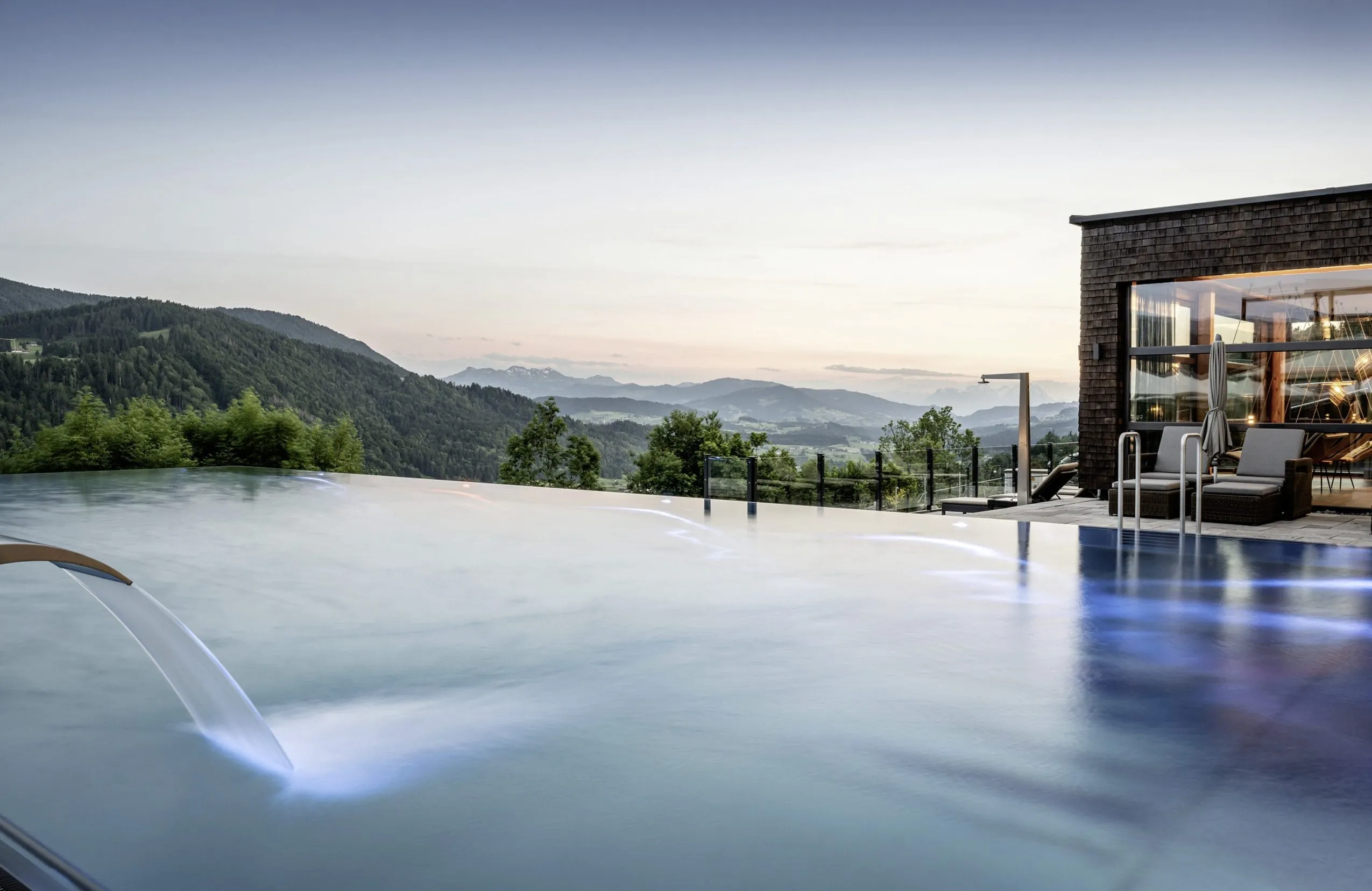 Outdoor-Infinitypool des Bergkristall in der Abenddämmerung mit einem weiten Blick über die Allgäuer Landschaft