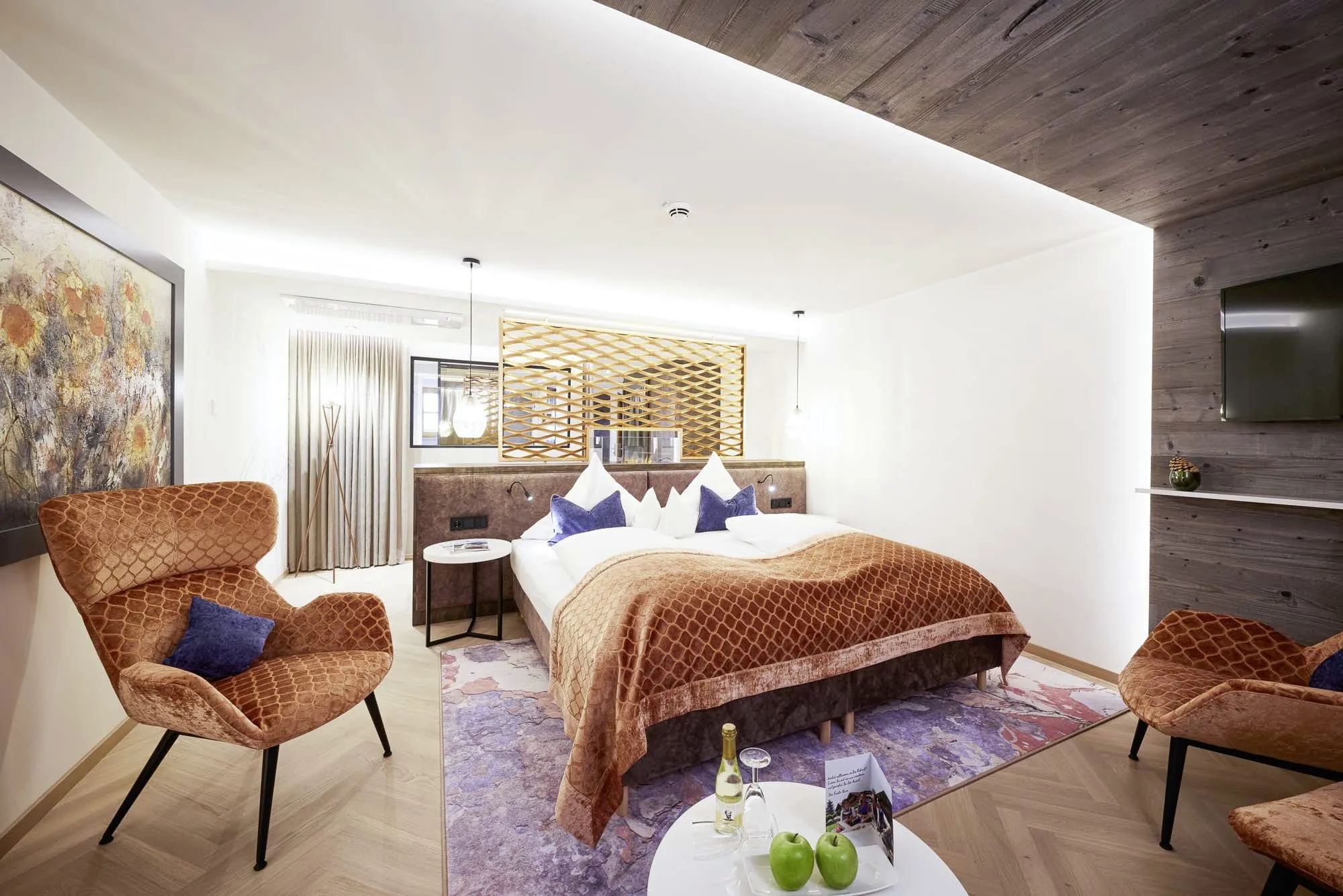 Zimmer im Das R&uuml;bezahl mit terrakottafarbenem Bett&uuml;berwurf und Sessel