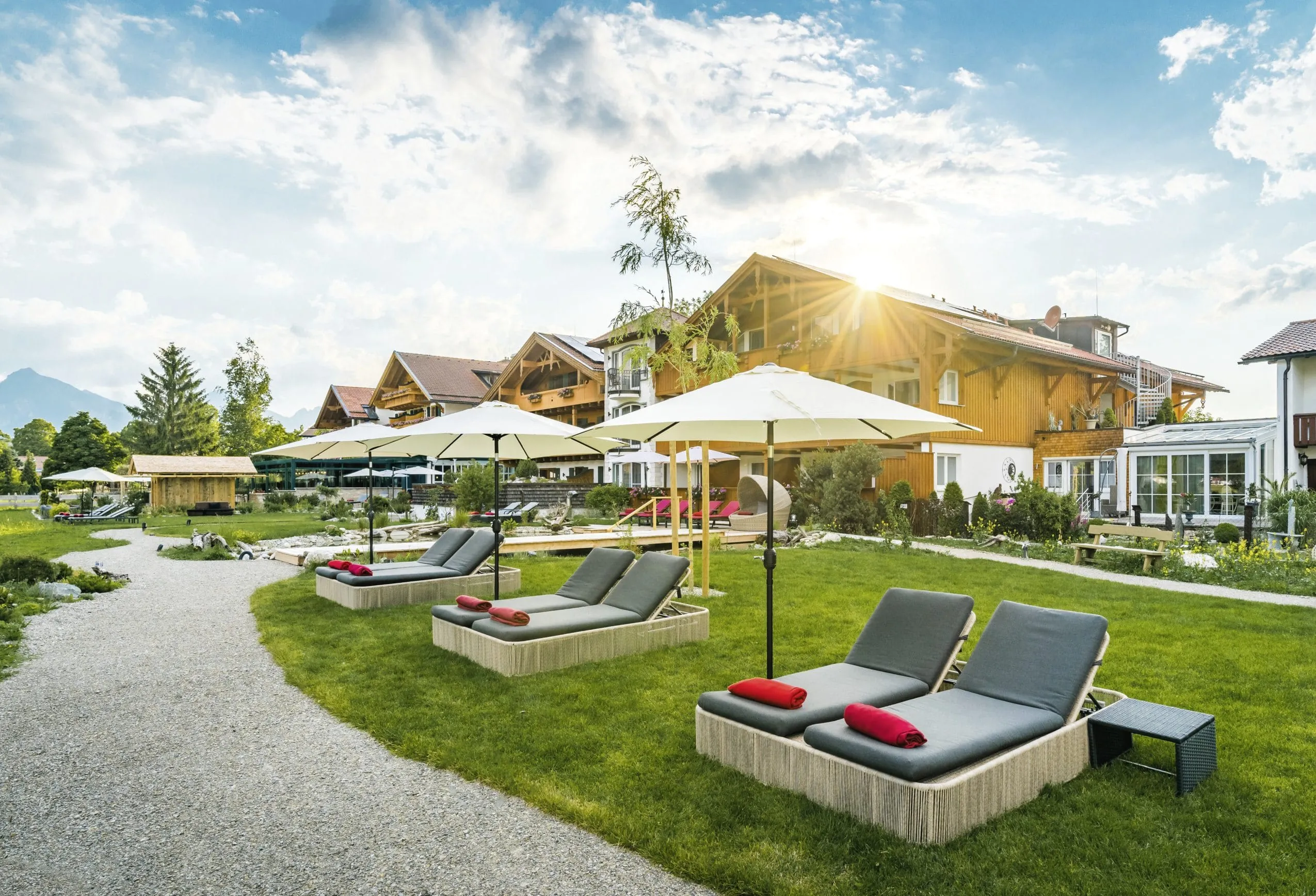 Ruheliegen unter wei&szlig;en Sonnenschirmen im Wellnessgarten des Hotel R&uuml;bezahl im Allg&auml;u