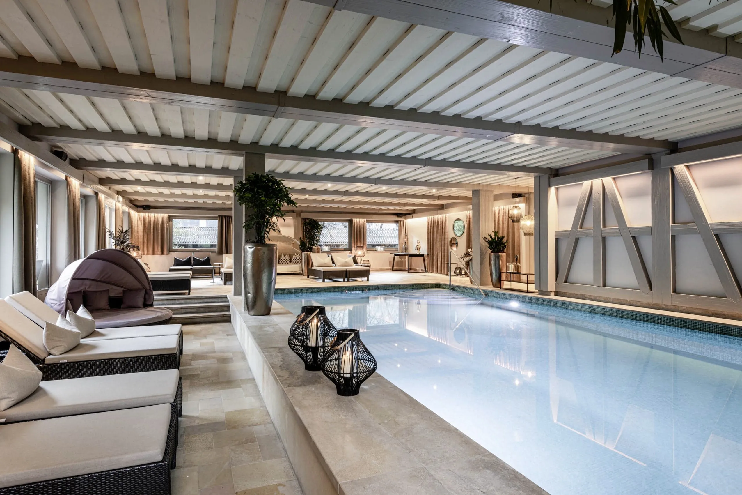 Indoorpool mit Holzdecke und Korbleuchten im Romantik Hotel Stafler in Südtirol