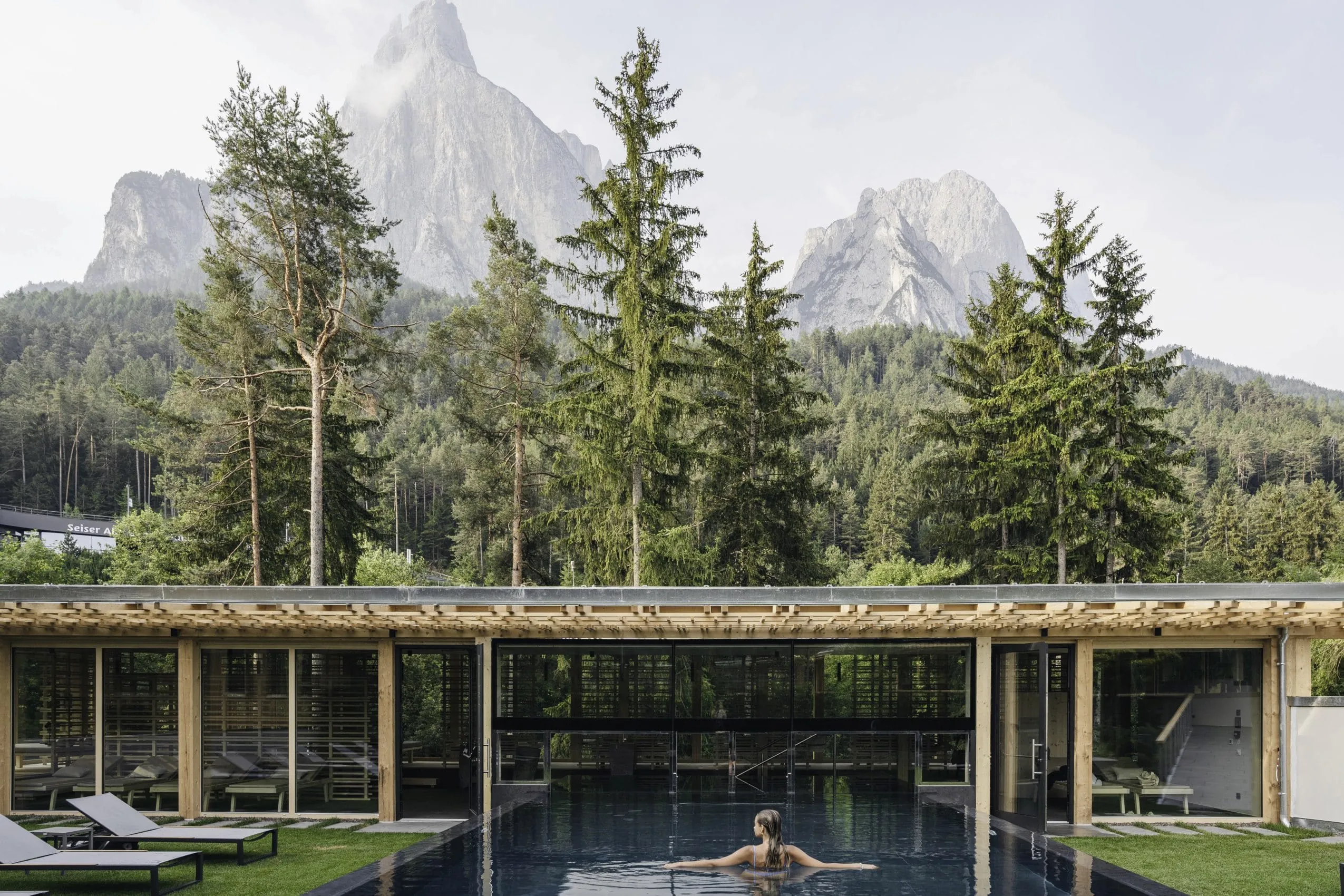Frau steht im Outdoorpool des Sensoria Dolomites mit Blick auf den Schlern
