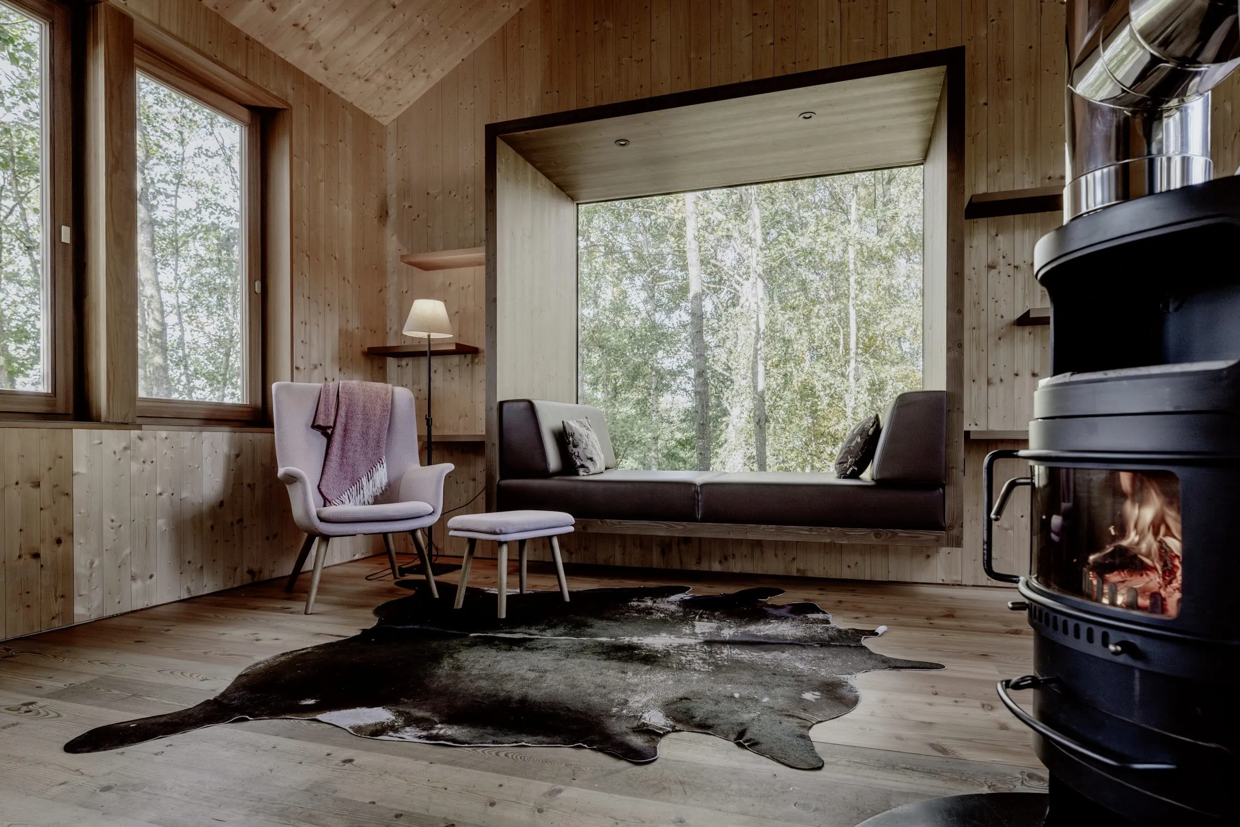 bollernder Schwedenofen vor der Kuschelecke am Panoramafenster des Hofgut Hafnerleiten